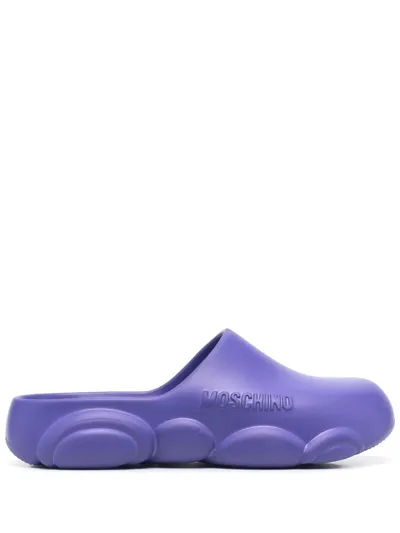 Moschino Logo Embossed Mules In Purple